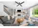 Inviting living room with a fireplace, built-in shelving, and a large window overlooking the backyard at 4235 Night Sky Ln, Cumming, GA 30041