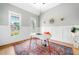 Bright home office with wainscoting, a modern desk, and a stylish rug on hardwood floors at 4235 Night Sky Ln, Cumming, GA 30041