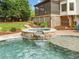 Inviting backyard pool with a stone hot tub and lush landscaping offers a relaxing outdoor space at 4235 Night Sky Ln, Cumming, GA 30041