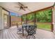 Inviting screened porch with ceiling fan, table, and a serene view of the backyard at 4235 Night Sky Ln, Cumming, GA 30041