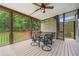 Relaxing screened porch with ceiling fan, outdoor table, and lush backyard views at 4235 Night Sky Ln, Cumming, GA 30041