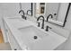 Bright bathroom featuring a double vanity with black fixtures, mirrors and view to a fireplace at 4336 Southvale Dr, Decatur, GA 30034