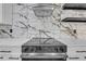 Modern kitchen features stainless steel range with marble backsplash, sleek design, and ample countertop space at 4336 Southvale Dr, Decatur, GA 30034