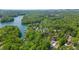 A scenic aerial view of a community nestled among lush trees near a serene river, offering a picturesque and tranquil setting at 6265 Reives Rd, Cumming, GA 30041