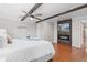 Modern bedroom featuring hardwood floors, a ceiling fan, a mounted TV with an electric fireplace, and ample natural light at 6265 Reives Rd, Cumming, GA 30041