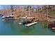 Waterfront home with a private boat dock featuring a covered lift and ladder access to the lake at 6265 Reives Rd, Cumming, GA 30041