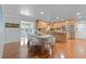 Open-concept dining area with hardwood floors connecting to the kitchen and sunroom at 6265 Reives Rd, Cumming, GA 30041