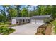 Charming home featuring a spacious driveway and three-car garage, complemented by manicured landscaping and inviting front porch at 6265 Reives Rd, Cumming, GA 30041