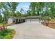 Beautiful home featuring manicured landscaping, a two-car garage, a covered front porch, and tasteful gray siding at 6265 Reives Rd, Cumming, GA 30041