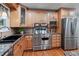 This is a kitchen with stainless steel appliances, granite countertops, and custom wood cabinets at 6265 Reives Rd, Cumming, GA 30041