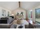 Bright living room featuring a vaulted ceiling, wood beam, gray sofa, and sliding doors to a deck at 6265 Reives Rd, Cumming, GA 30041