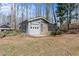 Detached outbuilding with garage door and attached greenhouse on a grassy lot at 6265 Reives Rd, Cumming, GA 30041