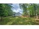 View of the home's rear exterior, showcasing the expansive backyard with lush green grass and mature trees at 2849 Appling Way, Kennesaw, GA 30152