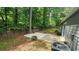 Spacious backyard with a small patio, wooden fence, and mature trees providing shade and privacy at 2849 Appling Way, Kennesaw, GA 30152