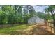 Side view of the house highlighting the well-maintained lawn, wooden fence, and mature trees at 2849 Appling Way, Kennesaw, GA 30152
