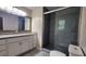 Bathroom with gray tiled shower, glass door, and granite countertop sink with white cabinets at 2849 Appling Way, Kennesaw, GA 30152