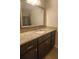 Modern bathroom vanity with granite countertop, dark cabinetry and framed mirror at 2849 Appling Way, Kennesaw, GA 30152