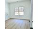 An empty bedroom with light, wood-look flooring and a large window for natural light at 261 Arborview Dr, Mcdonough, GA 30252