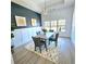 Elegant dining room featuring wainscoting, a modern chandelier, and natural light from large windows at 261 Arborview Dr, Mcdonough, GA 30252