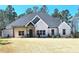 Charming light brick home with dark roof, front porch, and landscaped yard at 261 Arborview Dr, Mcdonough, GA 30252
