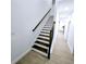 Staircase featuring dark wood treads and white risers, complemented by wood railing at 261 Arborview Dr, Mcdonough, GA 30252