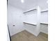 Walk-in closet features built-in shelving and closet rods at 261 Arborview Dr, Mcdonough, GA 30252