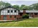 Brick two-story home with a chimney, French doors, landscaped yard, and outdoor seating area at 3996 Indian Manor Dr, Stone Mountain, GA 30083