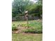 Garden bed with flowers and a birdhouse featured in a residential backyard with lawn and fencing at 3996 Indian Manor Dr, Stone Mountain, GA 30083