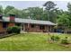 Brick home featuring a level backyard with a patio, lawn, flower beds, and assorted furniture at 3996 Indian Manor Dr, Stone Mountain, GA 30083