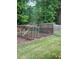 Backyard with garden bed and partially constructed wooden structure, bordered by a chain link fence at 3996 Indian Manor Dr, Stone Mountain, GA 30083