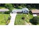 Aerial view of a two-story home with a large manicured lawn, mature trees, and a brick driveway at 3996 Indian Manor Dr, Stone Mountain, GA 30083