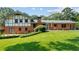 Expansive backyard features lush lawn, brick exterior, patio area, and mature landscaping, creating a private outdoor oasis at 3996 Indian Manor Dr, Stone Mountain, GA 30083