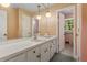 Bathroom featuring a vanity with sink and storage cabinets, with pink and floral wallpaper at 3996 Indian Manor Dr, Stone Mountain, GA 30083