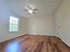 A bright bedroom features a ceiling fan, wood-look floors and a large window for natural light at 5229 Mountain Village Ct, Stone Mountain, GA 30083