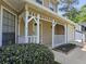 Home's quaint front porch, supported by white pillars, enhances curb appeal at 5229 Mountain Village Ct, Stone Mountain, GA 30083