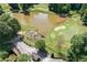 Aerial view of a golf course and pond with a bridge at 2023 Stoneleigh Dr, Stone Mountain, GA 30087