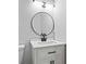 Modern bathroom with round mirror, updated vanity with white countertop and black hardware at 2023 Stoneleigh Dr, Stone Mountain, GA 30087