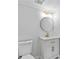 Bathroom featuring white vanity, gold faucet, gold light fixture, round mirror, and white toilet at 2023 Stoneleigh Dr, Stone Mountain, GA 30087