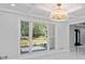 Dining area with a modern chandelier, large windows overlooking the backyard, and white marble floors at 2023 Stoneleigh Dr, Stone Mountain, GA 30087