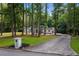 Long driveway leads to this home nestled among trees, with well-manicured lawn at 2023 Stoneleigh Dr, Stone Mountain, GA 30087