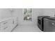 Modern laundry room with white cabinets, gold hardware, marble counters, and a front-loading washer and dryer at 2023 Stoneleigh Dr, Stone Mountain, GA 30087