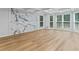 Sun-filled living room with hardwood floors, statement wall with marble accent, and a wall of windows at 2023 Stoneleigh Dr, Stone Mountain, GA 30087