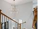 Elegant staircase with wooden railing, black wrought iron spindles, and a modern chandelier above at 2023 Stoneleigh Dr, Stone Mountain, GA 30087