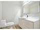 Modern bathroom with a minimalist white vanity, sleek faucet, large mirror, and new toilet at 3139 Alston Dr, Decatur, GA 30032