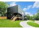 Modern dark home with wood stairs, a back porch, and a well-manicured lawn at 3139 Alston Dr, Decatur, GA 30032