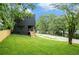 Modern dark home with wood stairs, a back porch, and a lush green lawn at 3139 Alston Dr, Decatur, GA 30032