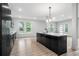 Modern kitchen boasts an island, sleek black cabinetry, recessed lighting, and stylish wood floors at 3139 Alston Dr, Decatur, GA 30032