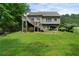 Expansive backyard featuring a deck with stairs and surrounded by mature trees and landscaping at 33 Kay Ne Rd, White, GA 30184