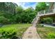 Serene backyard with a stone pathway leading to a firepit, deck and lush surroundings at 33 Kay Ne Rd, White, GA 30184