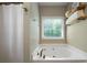 Bright bathroom features a soaking tub with a window and wooden shelves at 33 Kay Ne Rd, White, GA 30184